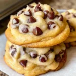 Stack of soft chocolate chip cookies with a glass of milk.