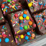 Chewy Christmas candy brown sugar cookies with melted Reese's and crushed M&Ms on a wire rack